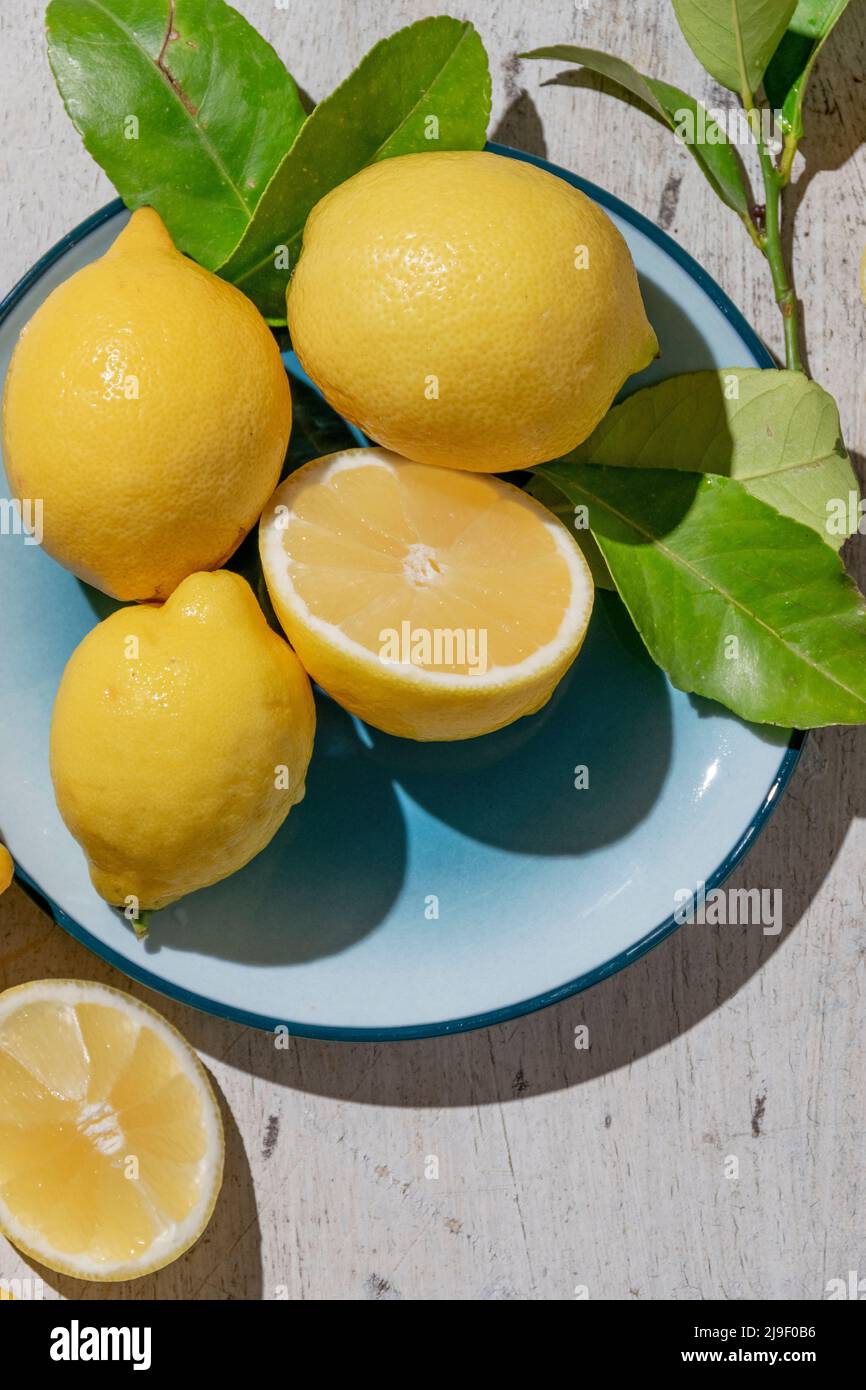 Limoni freschi crudi su sfondo di legno chiaro. Raccolto, concetto agricolo, ingredienti biologici sani Foto Stock