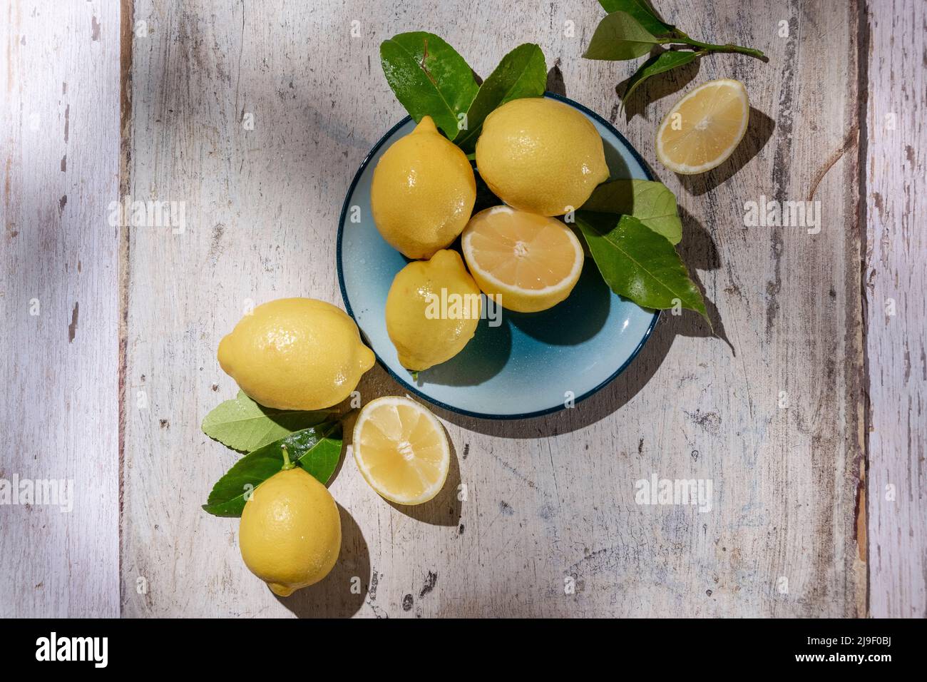 Limoni freschi crudi su sfondo di legno chiaro. Raccolto, concetto agricolo, ingredienti biologici sani Foto Stock