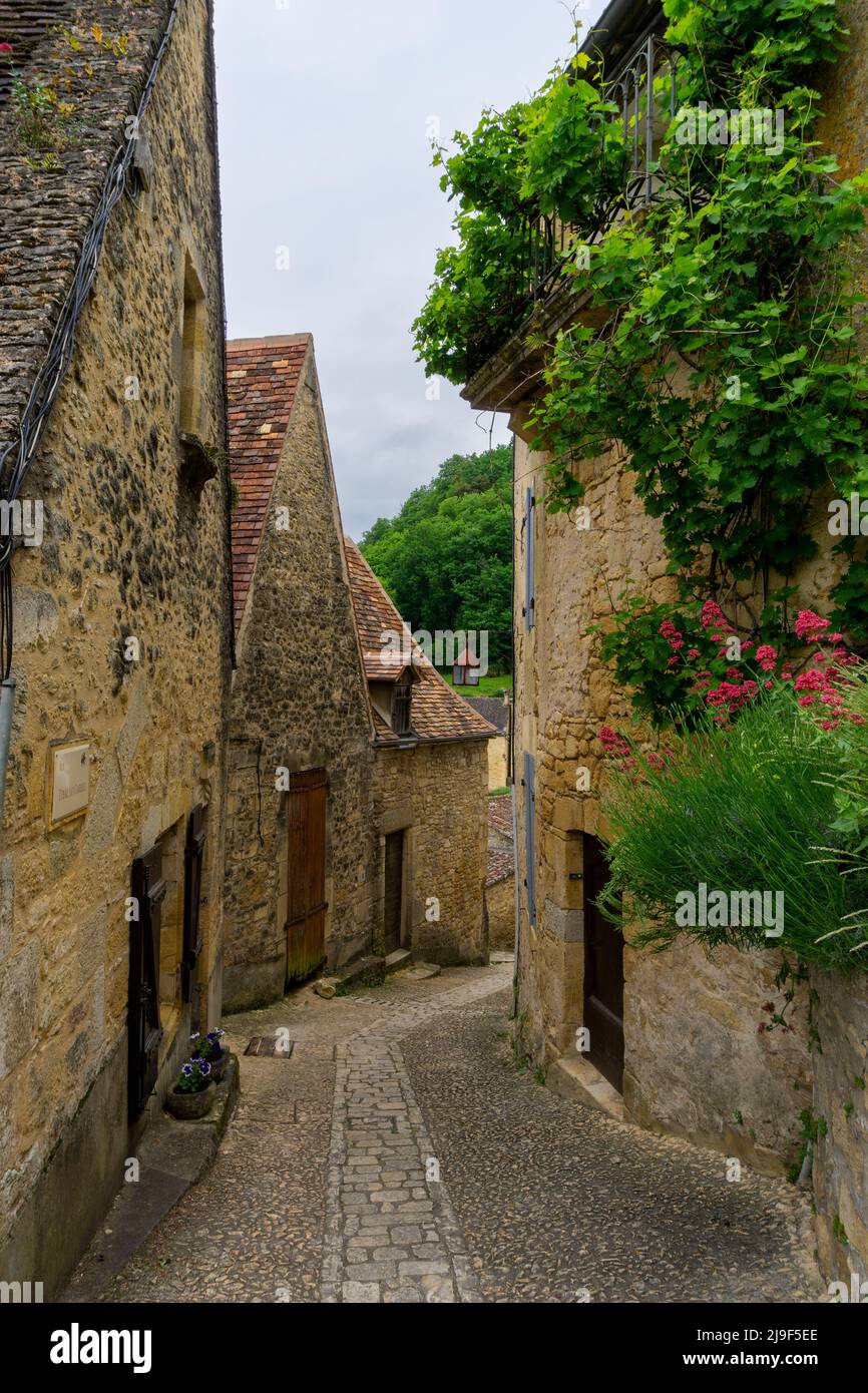 Beynac-et-Cazenac, Francia - 12 maggio, 2022: Strada acciottolata stretta con case in pietra pittoresco nel villaggio storico di Beynac-et-Cazenac Foto Stock