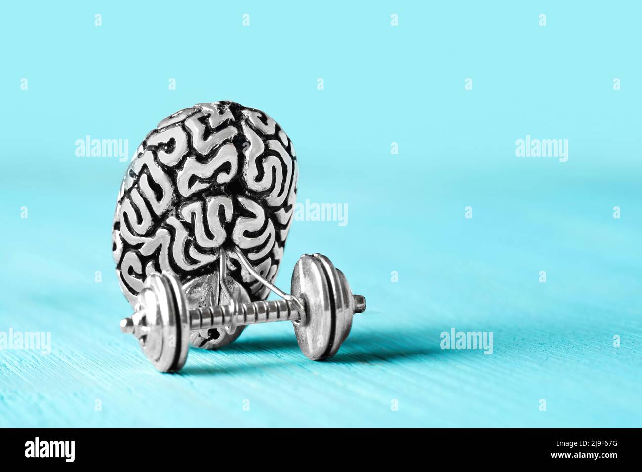 Copia di acciaio del cervello umano che solleva un dumbbell. Concetto di allenamento cerebrale. Foto Stock