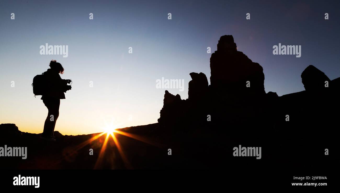 Una persona che filma il tramonto nel Parco Nazionale del Teide a Tenerife, Spagna. Il parco è la sede del Monte Teide, Foto Stock