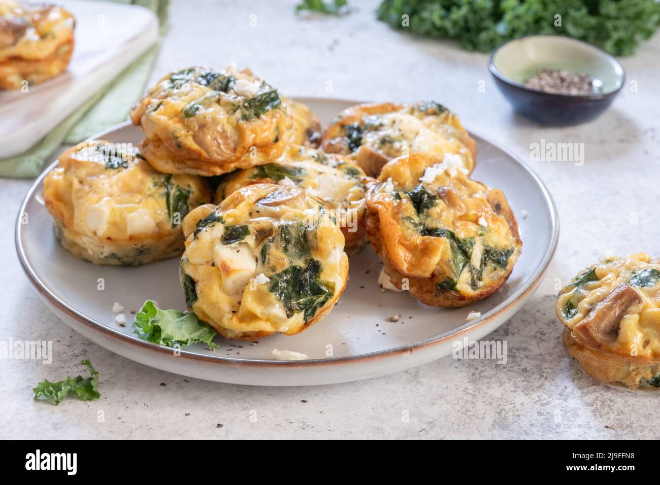 Muffin vegetariani alle uova con funghi, kale e formaggio feta per colazione Foto Stock