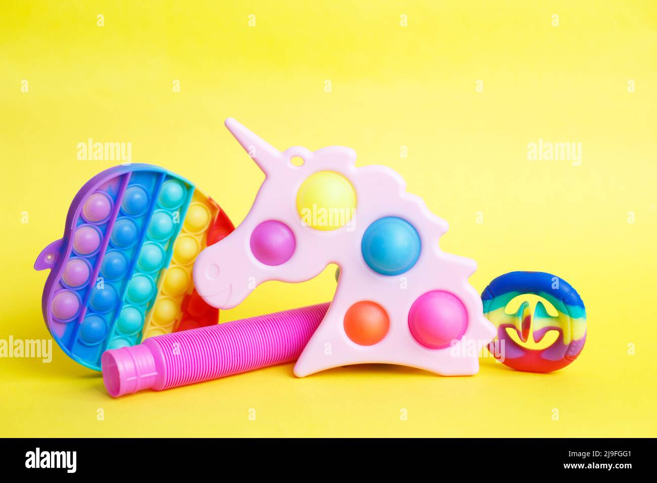 colorati giochi di fedget sensoriali antistress su sfondo giallo Foto Stock