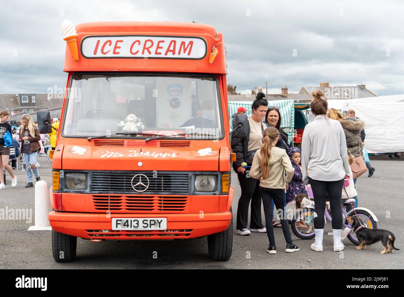 Persone che si accingono a un furgone gelato al porto di Tamble, Northumberland, Regno Unito. Foto Stock