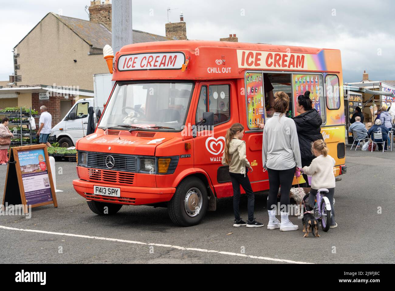Persone che si accingono a un furgone gelato al porto di Tamble, Northumberland, Regno Unito. Foto Stock