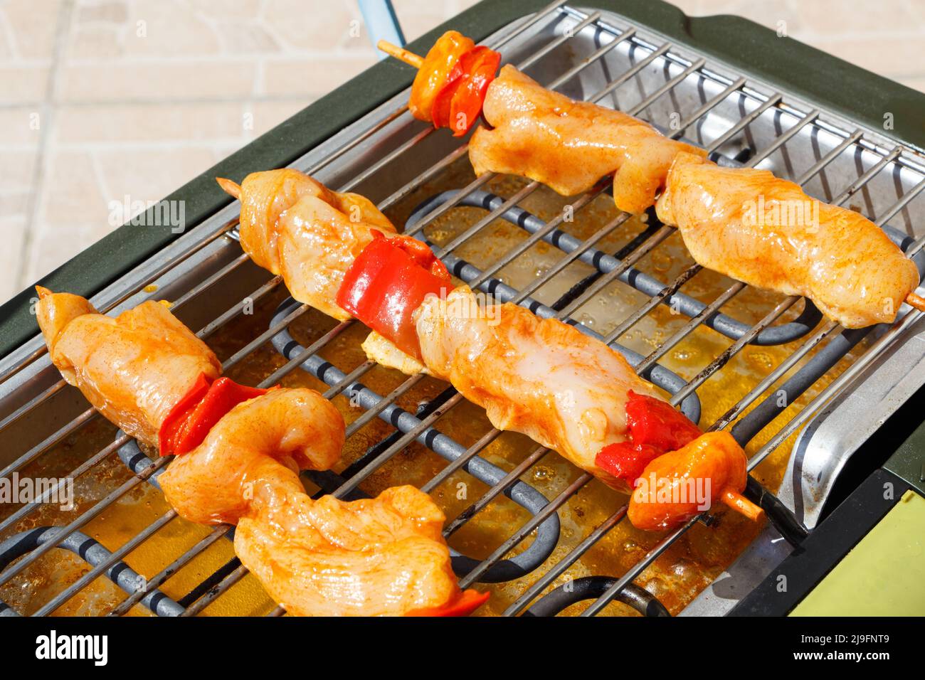 Brocetta di pollo marinata sulla griglia di un barbecue elettrico Foto Stock