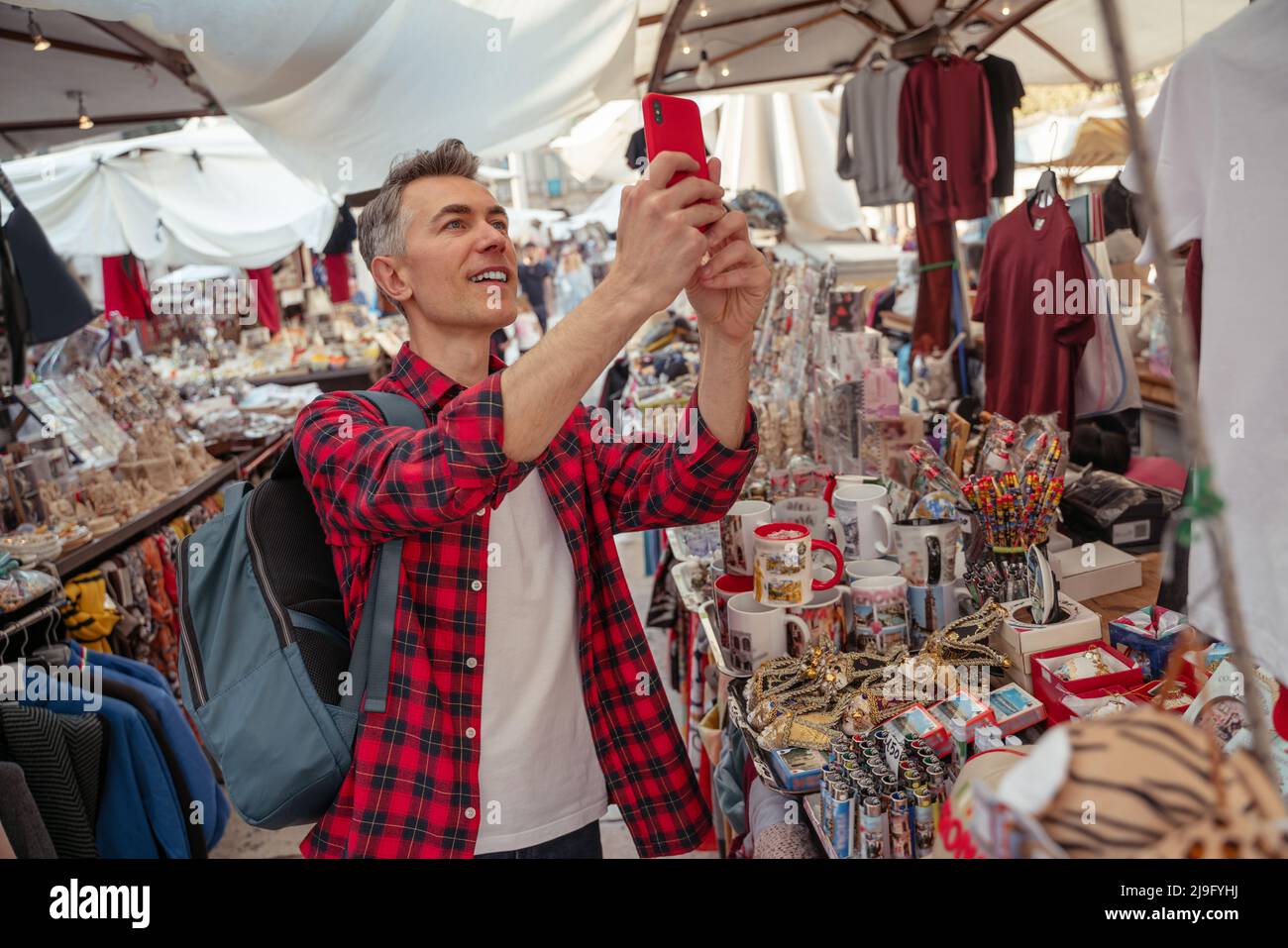 Uomo con smartphone che fotografa sette nel mercato Foto Stock