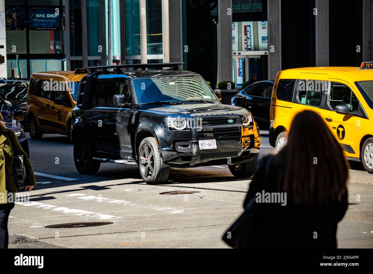 New Land Rover Defender a New York neben einem taxi Yellow Cab Foto Stock
