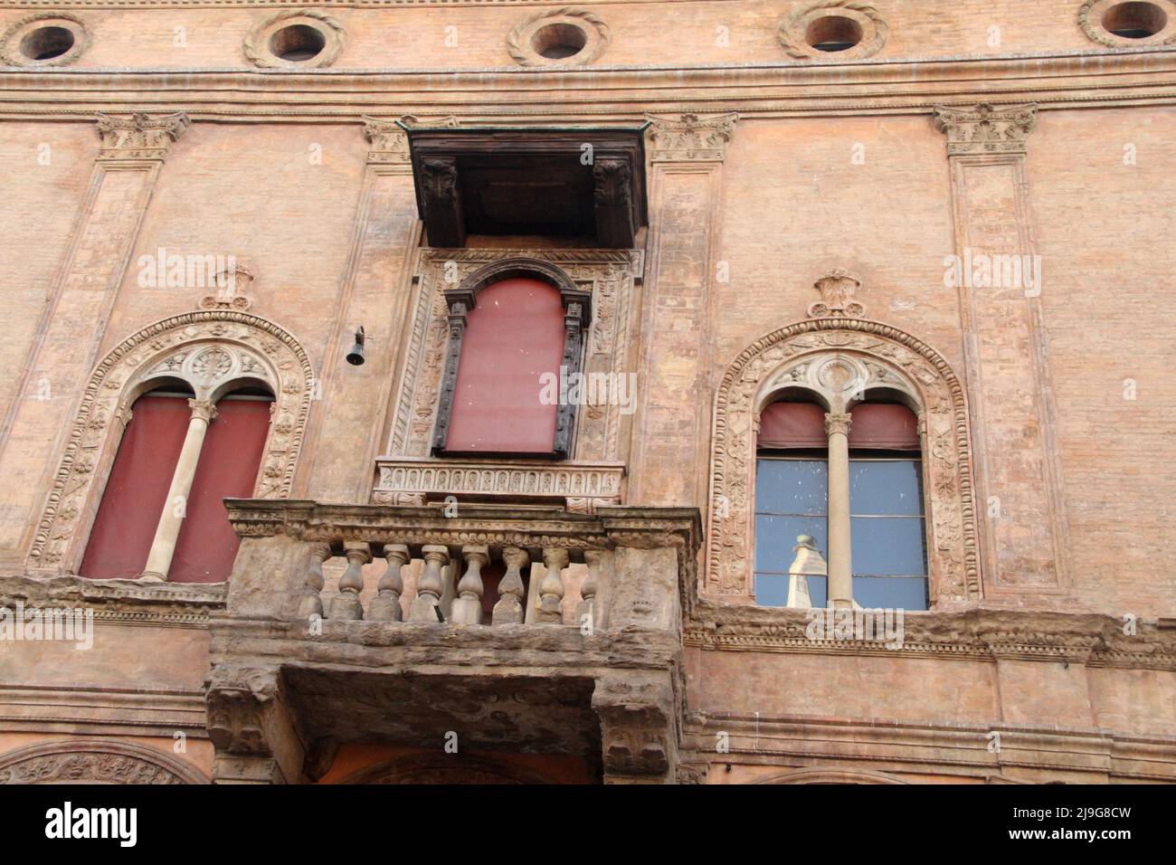 Bologna, Italia. Facciata splendidamente decorata di un edificio nel centro storico, con piccolo balcone e finestre a due lancette. Foto Stock