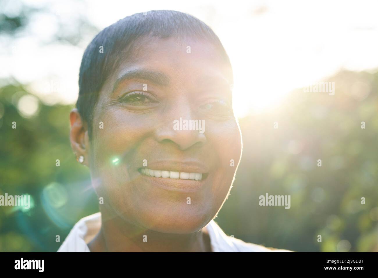 Primo piano di una donna sorridente in giardino Foto Stock