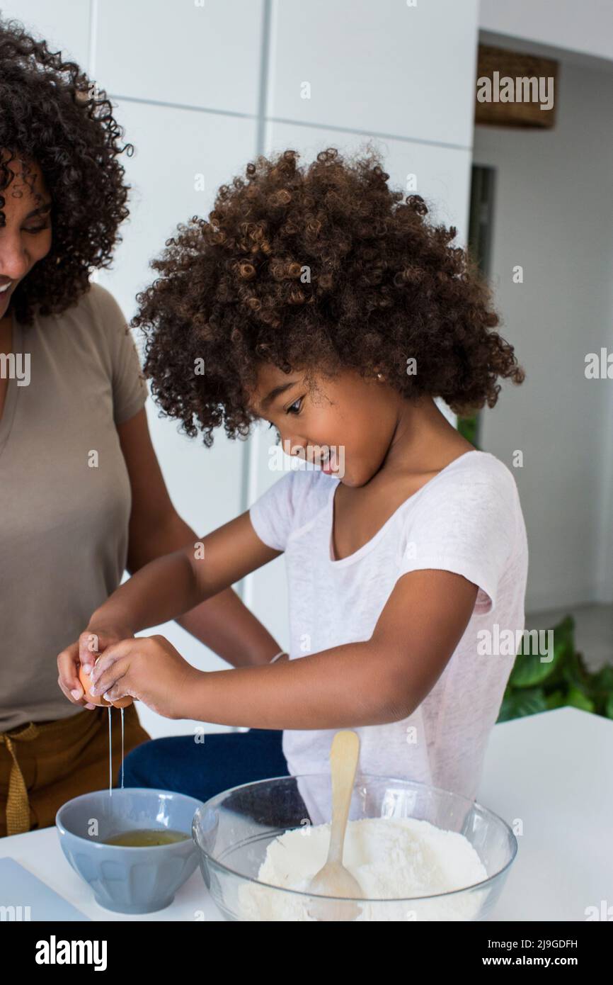 Giovane ragazza che prepara i biscotti con sua madre Foto Stock