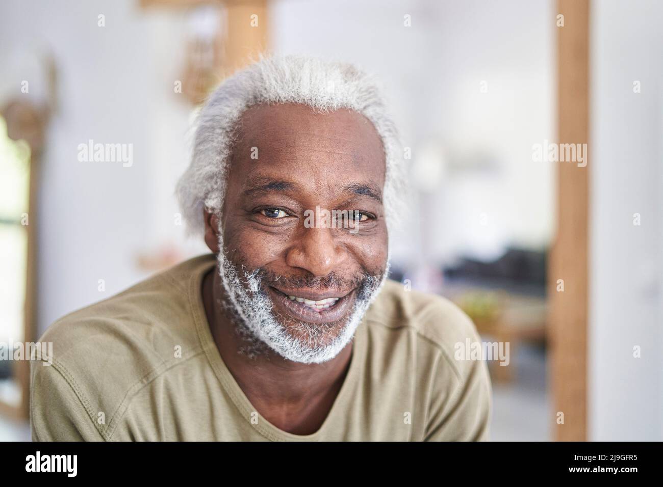 Uomo anziano sorridente in cucina Foto Stock