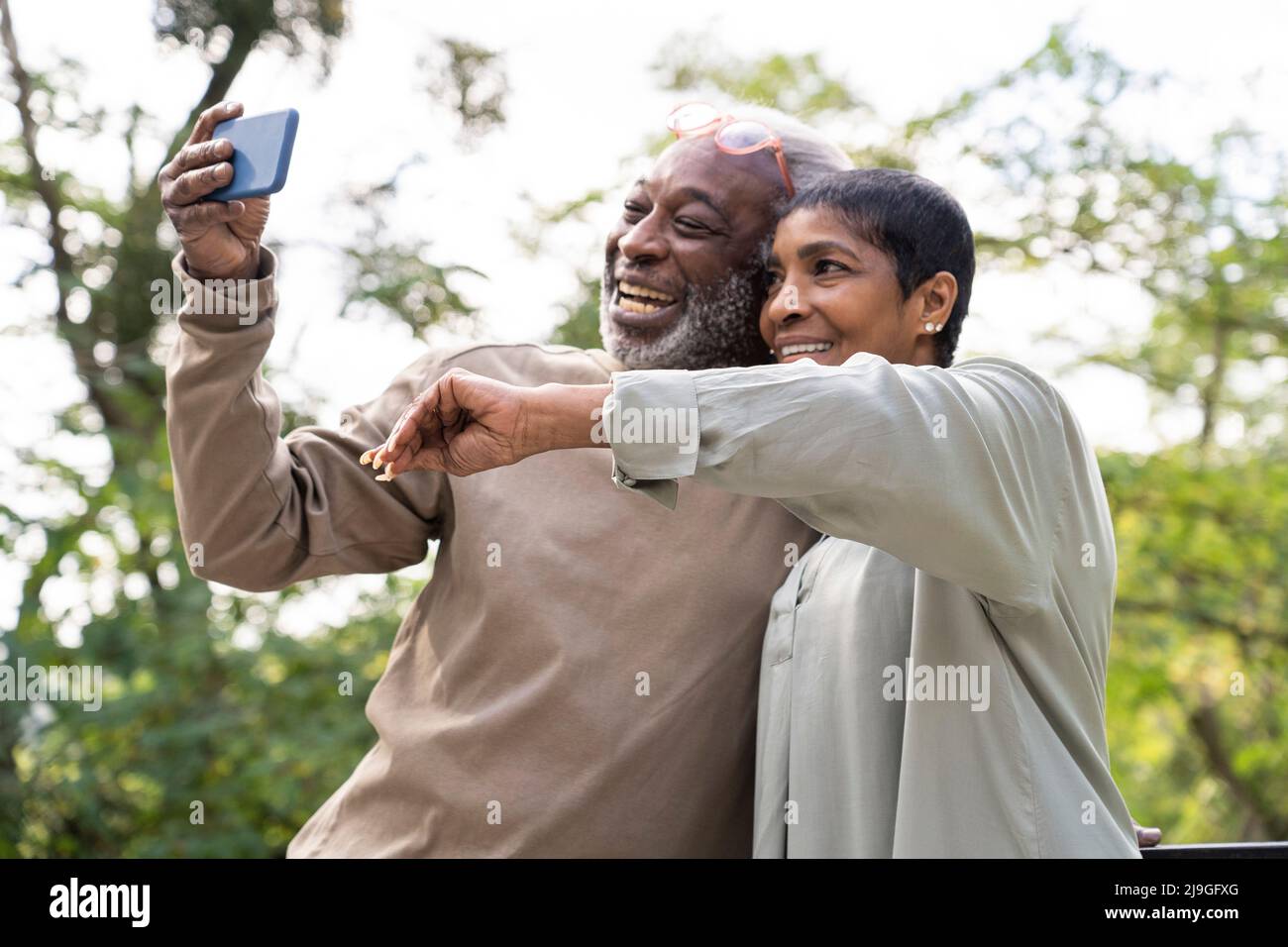 Coppia sorridente che prende selfie con smartphone Foto Stock