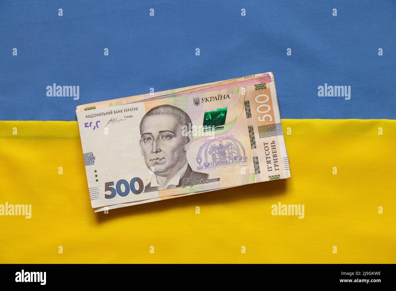 Il denaro ucraino si trova sulla bandiera nazionale dell'Ucraina, la finanza in Ucraina, l'economia del paese Foto Stock