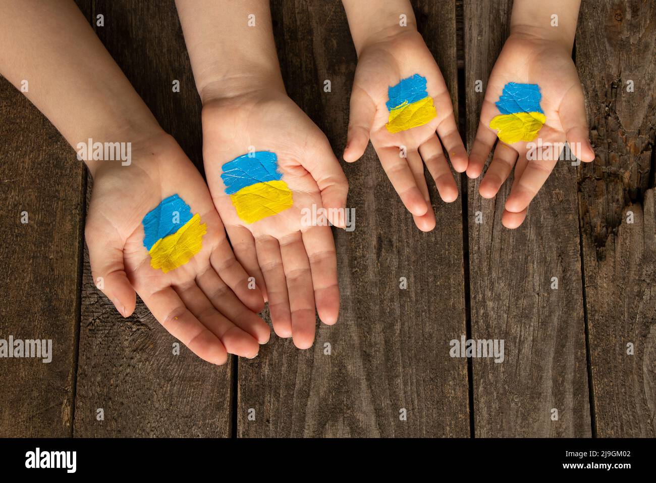 Mani di madre e bambino con bandiera blu-gialla disegnata dell'Ucraina. Legge marziale in Ucraina 2022. Fermare la guerra e la pace, popolo pacifico Ucraina, protesta ac Foto Stock