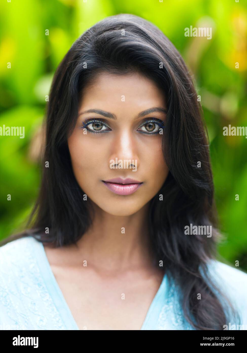 Una donna indiana in un abito turchese presso i giardini di Kairali Ayurvedic Health Resort, Palakkad, Kerala, India. Foto Stock