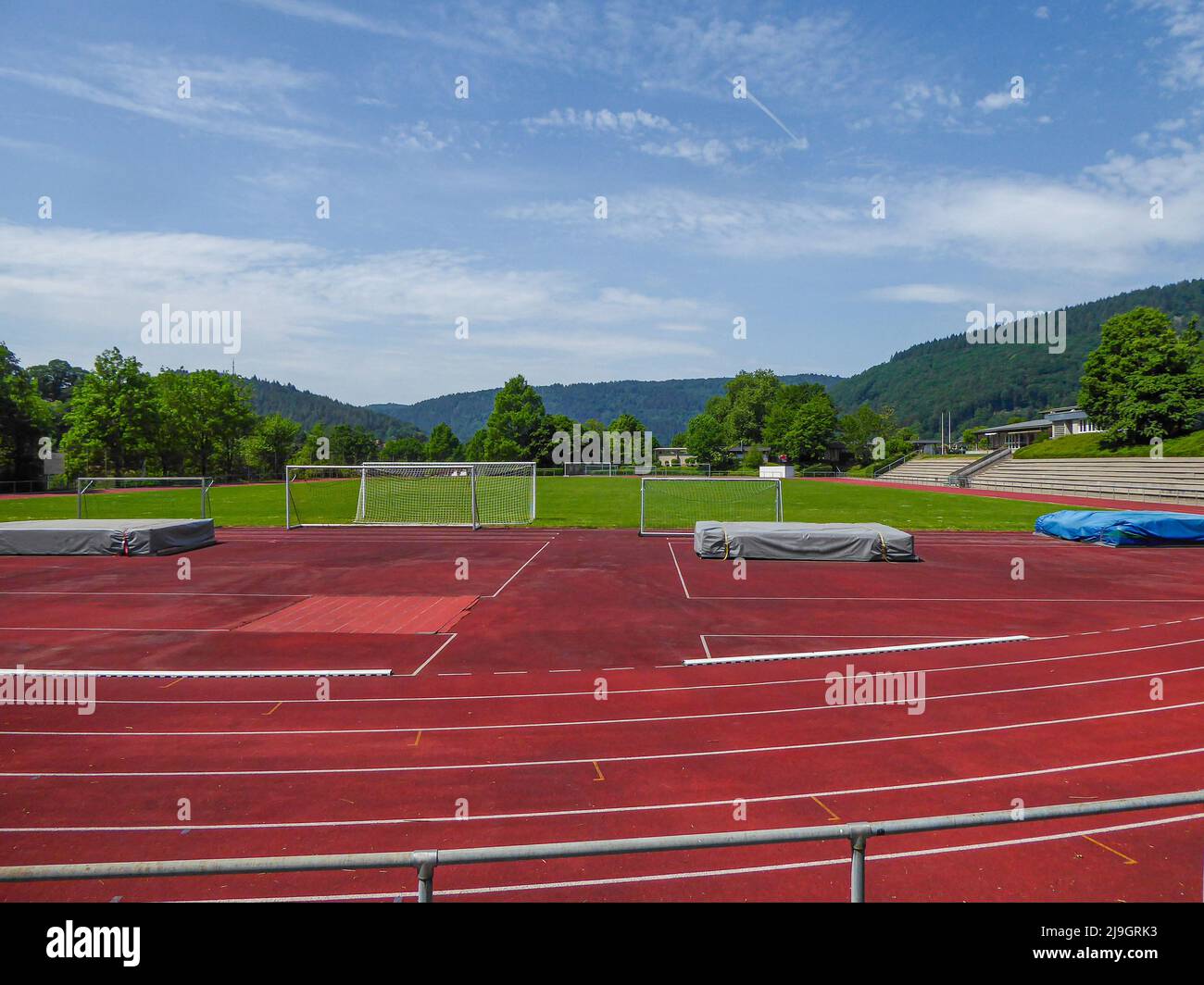 piccolo stadio comunale con campo d'erba, pista di atletica rossa e tribune nella germania meridionale Foto Stock