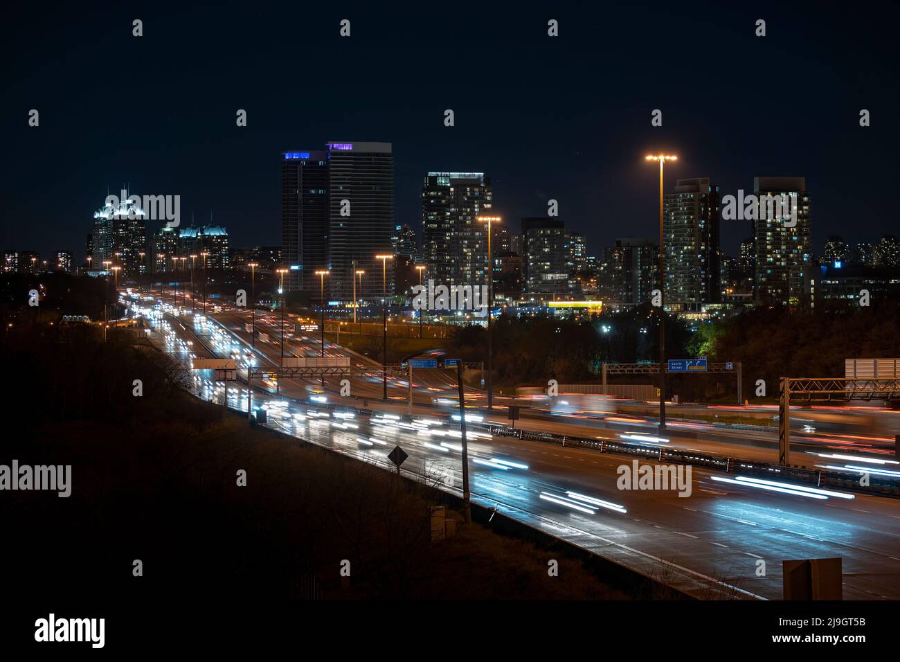 Belle luci della città, paesaggio urbano, esposizione lunga di notte da DVP auto veloce, traffico di velocità su 401 Foto Stock