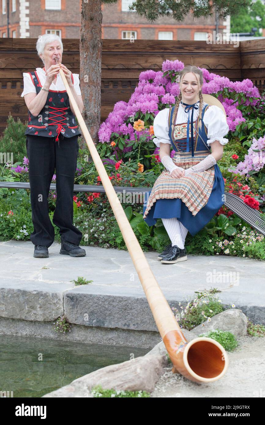 Londra, UK, 23 maggio 2022: Giornata di anteprima al Chelsea Flower Show: Una donna suona il corno alpino in costume tradizionale. Anna Watson/Alamy Live News Foto Stock