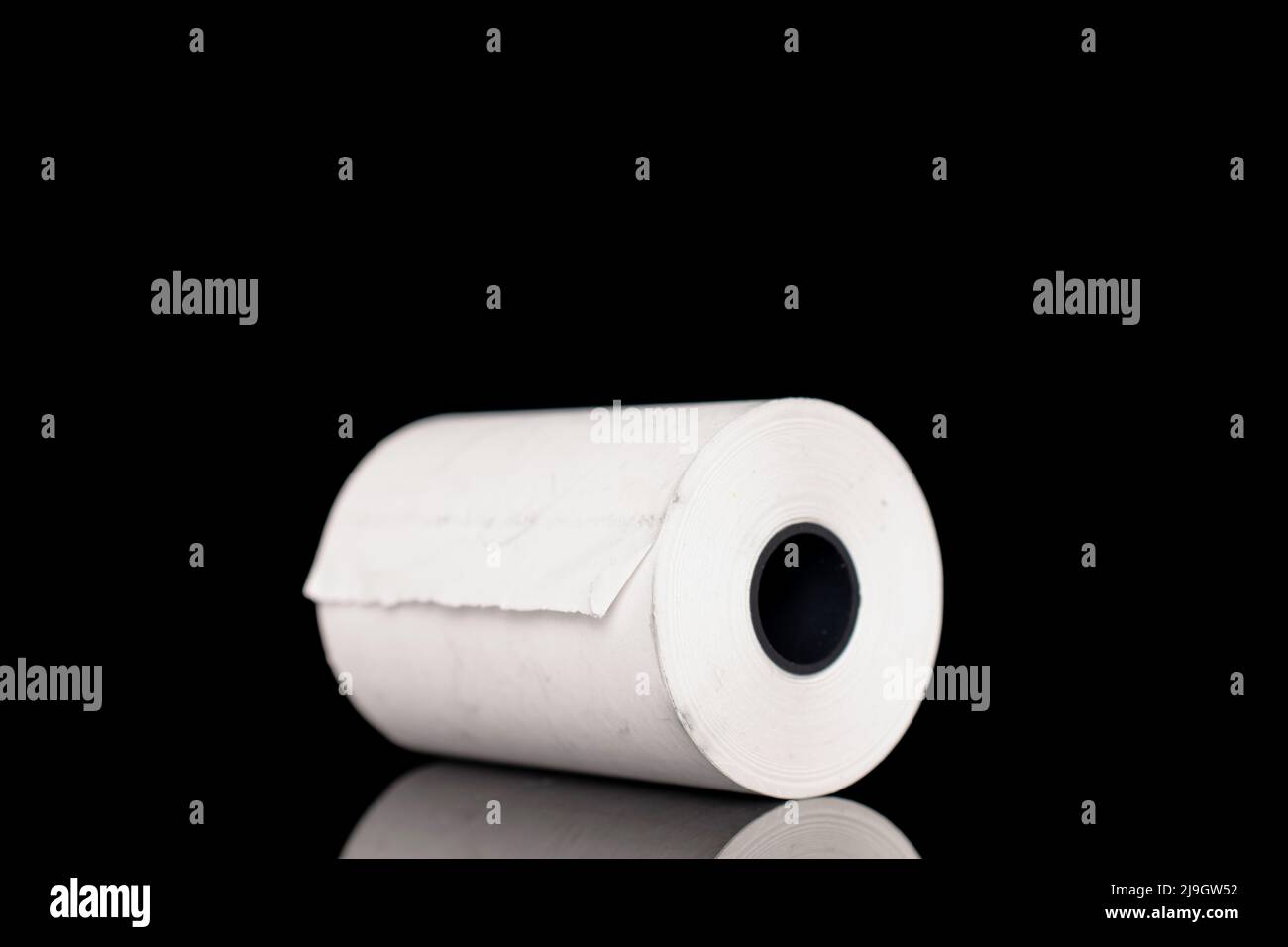Un rotolo di nastro di carta per contanti, isolato in primo piano su nero. Foto Stock