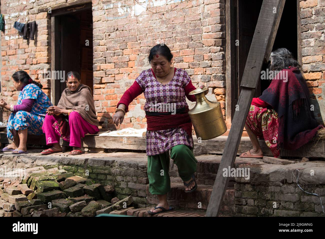 Kathmandu, Nepal- Aprile 20,2022 : le donne lavano vestiti e piatti sulle strade di Piazza Patan Durbar. Foto Stock