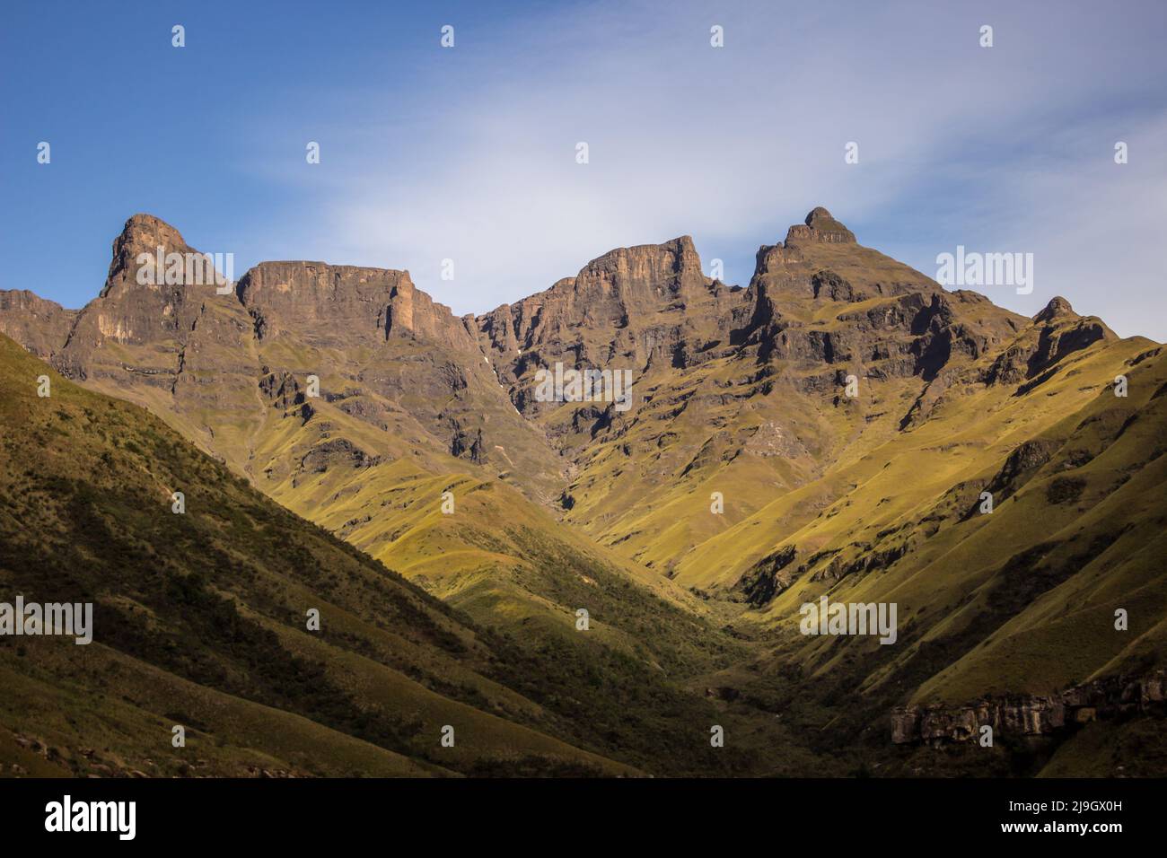 Le alte scogliere scoscese nella regione Injisuti dei Monti Drakensberg in una chiara giornata di sole Foto Stock