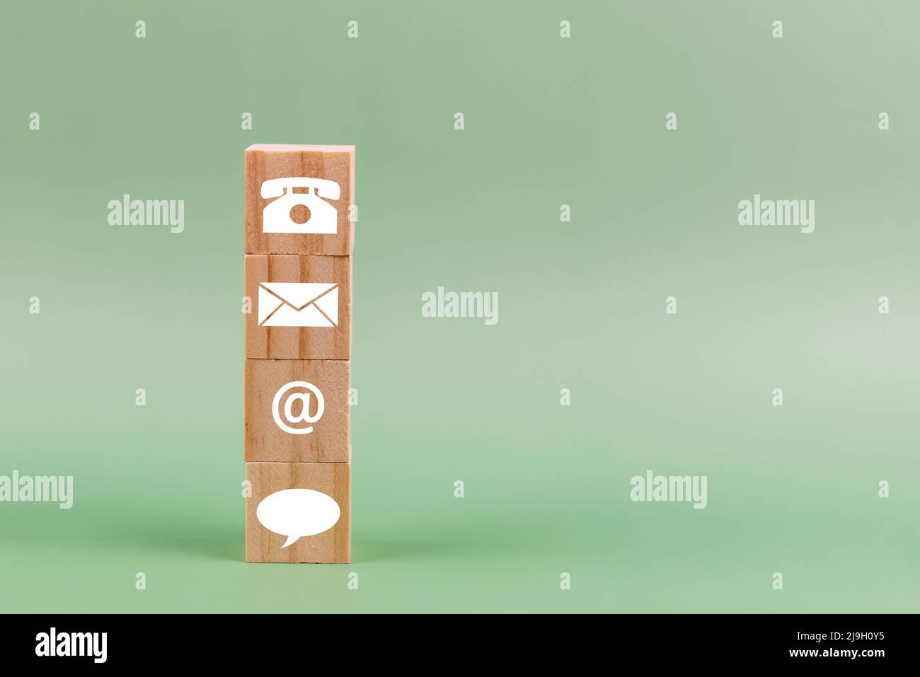 Contattaci icona su legno blocco sfondo verde - business concept con spazio copia Foto Stock