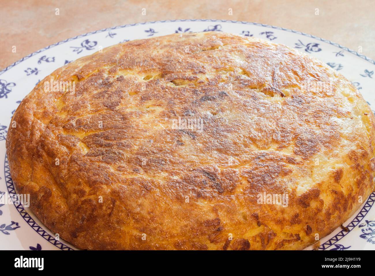 Primo piano di una grande frittata di patate su un piatto decorativo. Piatti fatti in casa e tradizionali. Foto Stock