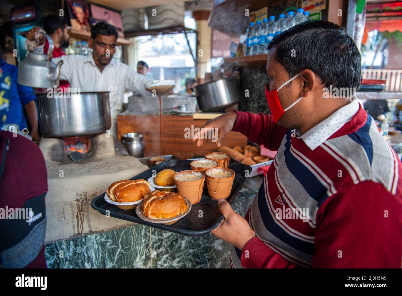 New Delhi, India. 18th Feb 2022. Il cameriere locale prepara il tè per la gente alla stalla del tè Sharma a Hazratganj. Il tè è parte integrante della vita quotidiana in India. Credit: SOPA Images Limited/Alamy Live News Foto Stock