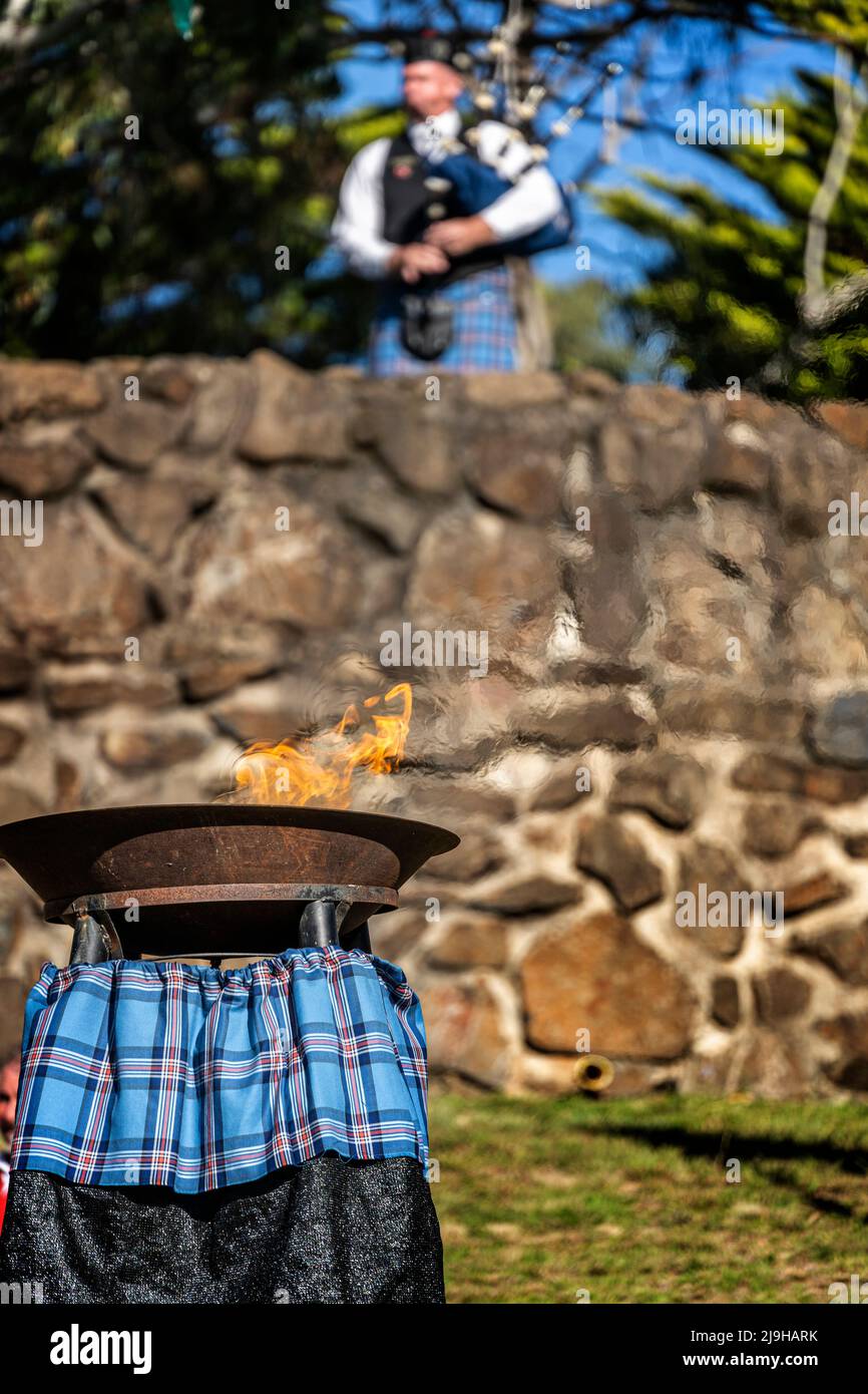 Il piper di Lone suona le cornamuse sopra la fiamma dell'amicizia alle pietre di standing, festival celtico di Glen Innes NSW Australia Foto Stock