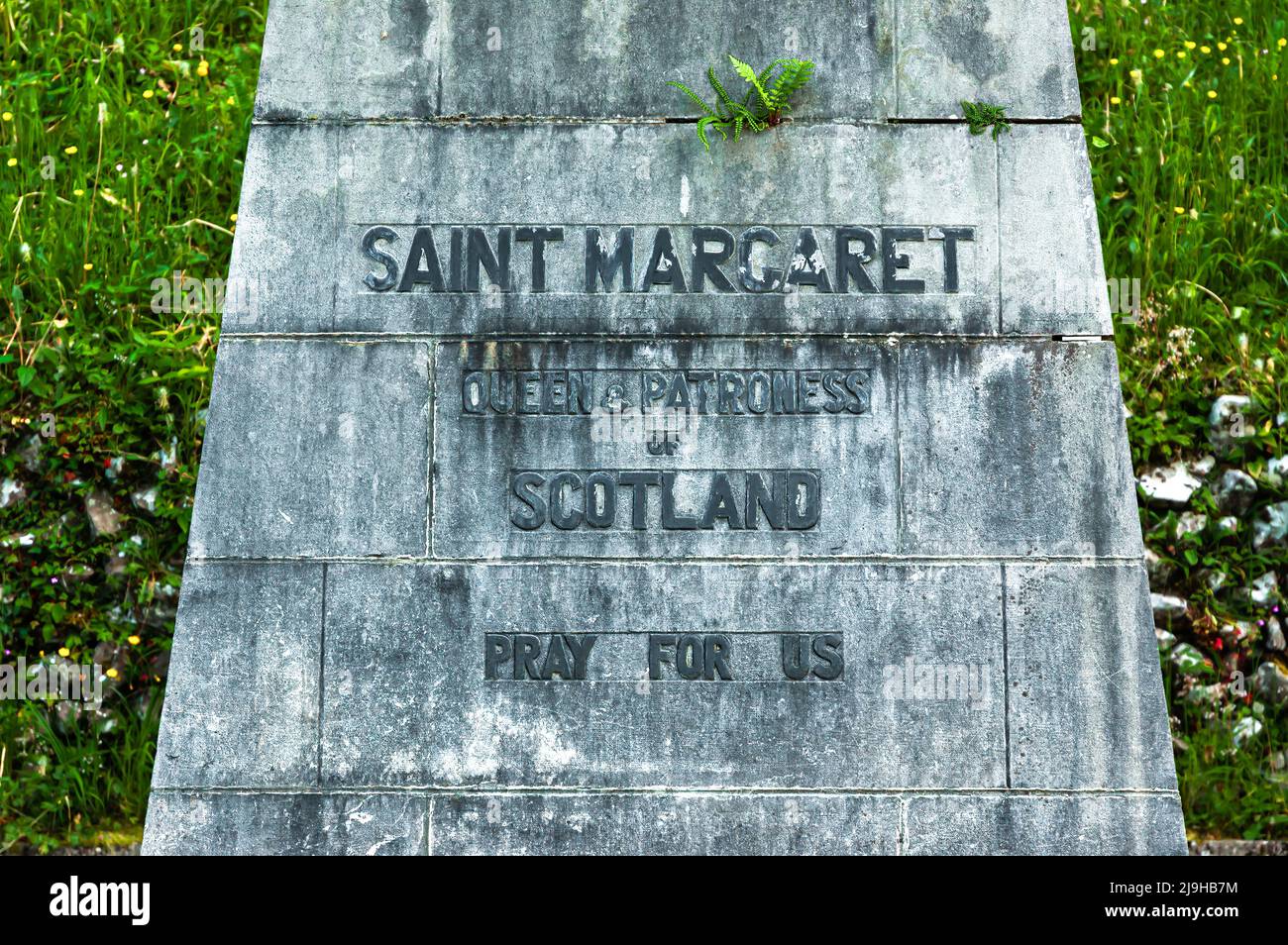 Lourdes, Francia - 18 maggio 2022: Iscrizione sotto la sua statua a Lourdes: Santa Margherita, regina e patrona della Scozia, prega per noi. Foto Stock