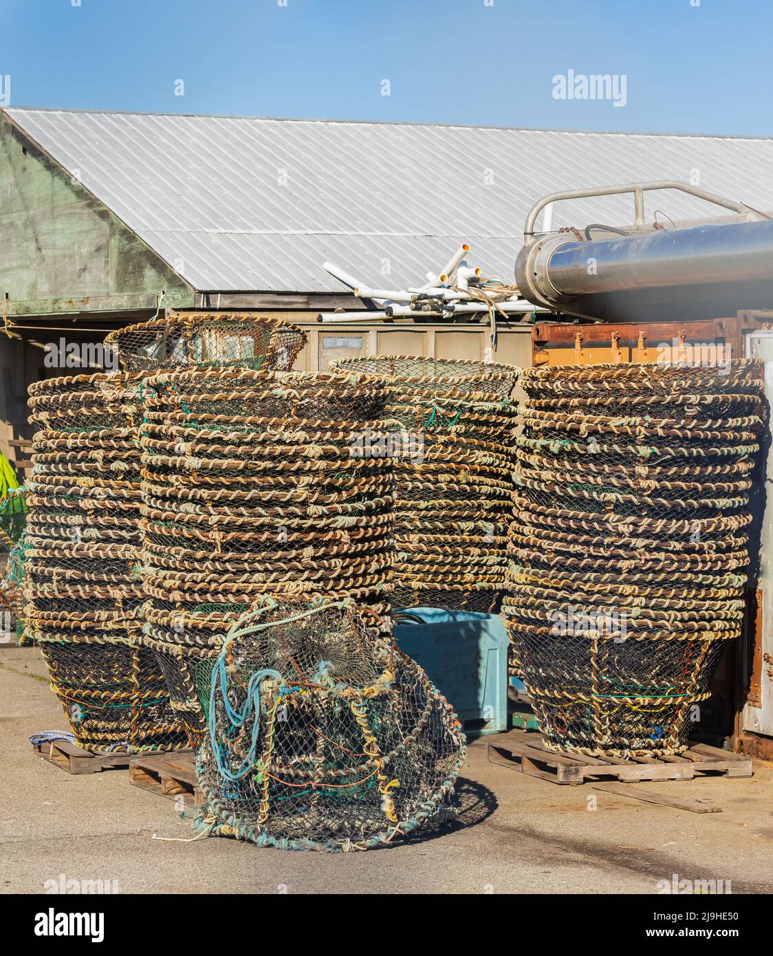 Gabbie di pesca del granchio su un kay in un porto. Le trappole colorate sono impilate e pronte per l'uso. Foto di strada, nessuno, fuoco selettivo Foto Stock