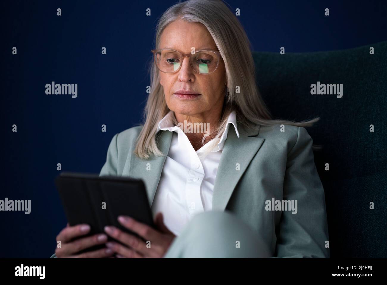 Donna d'affari che utilizza un tablet PC su sfondo blu Foto Stock