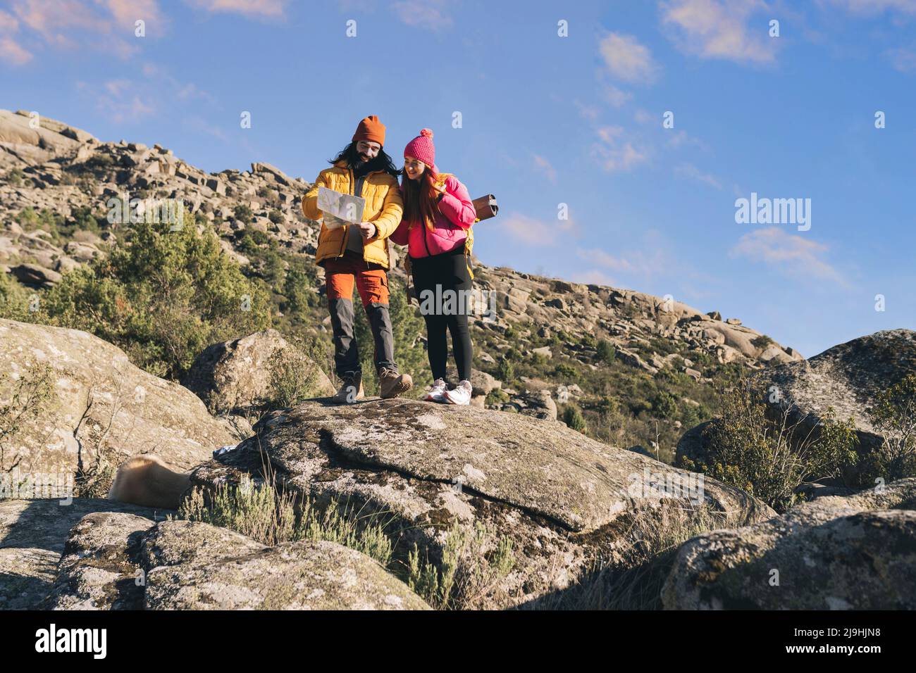 Uomo e donna leggendo la mappa in piedi sulla roccia Foto Stock