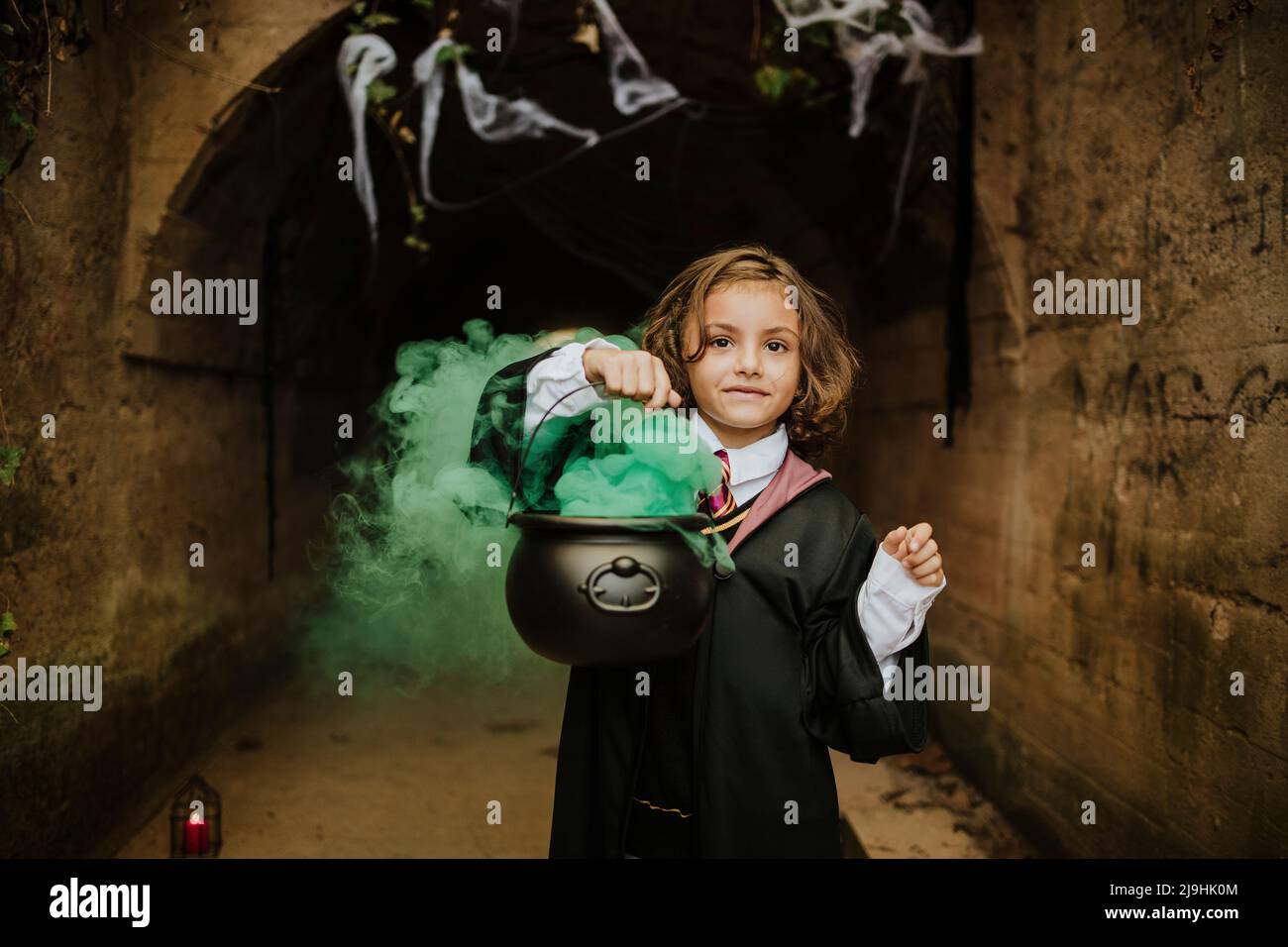 Carina ragazza che tiene il cavoldron con le streghe Brew indossare costume strega in tunnel spooky Foto Stock