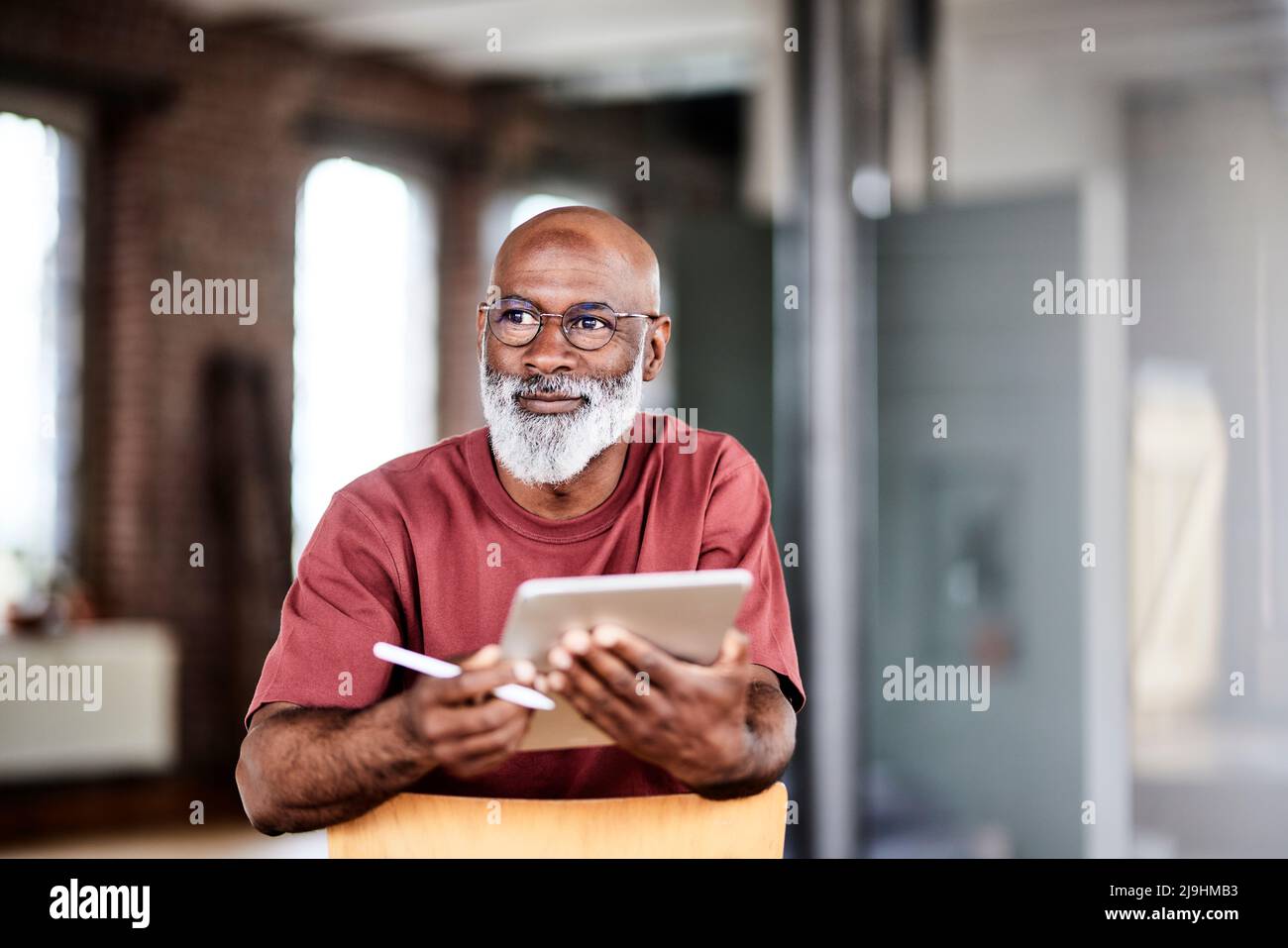 Uomo premuroso con penna digitale e tablet a casa Foto Stock