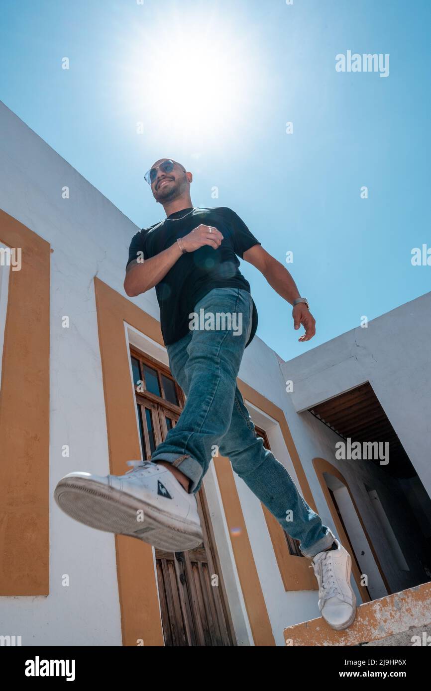 il giovane latino fa un grande passo nel vuoto in una casa coloniale Foto Stock