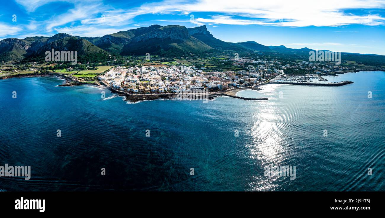 Spagna, Isole Baleari, Colonia de Sant Pere, Elicotteri panorama della città costiera in estate con montagne sullo sfondo Foto Stock