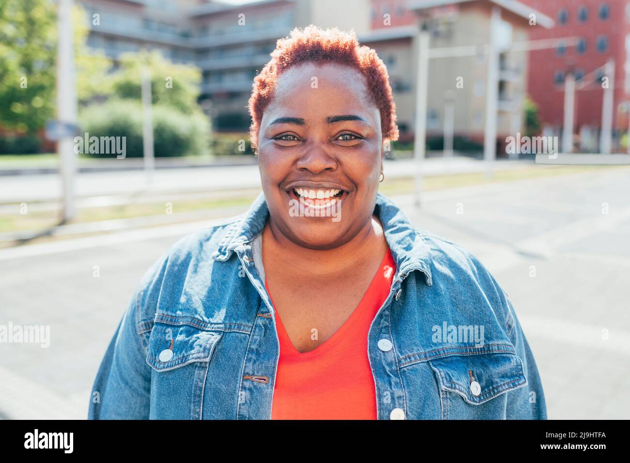 Donna matura allegra con capelli corti in giornata di sole Foto Stock