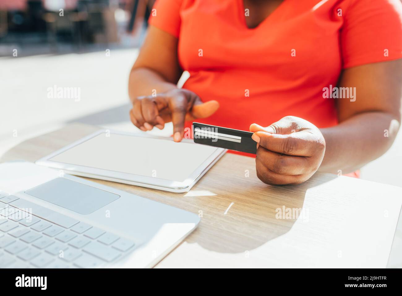 Donna matura in possesso di carta di credito facendo shopping online anche se tablet PC in giornata di sole Foto Stock