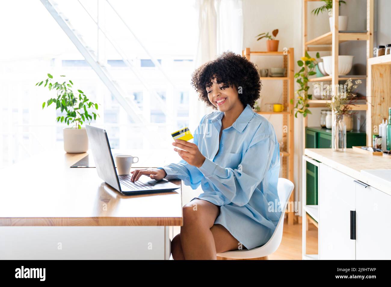 Donna felice che effettua il pagamento tramite carta di credito sul portatile Foto Stock