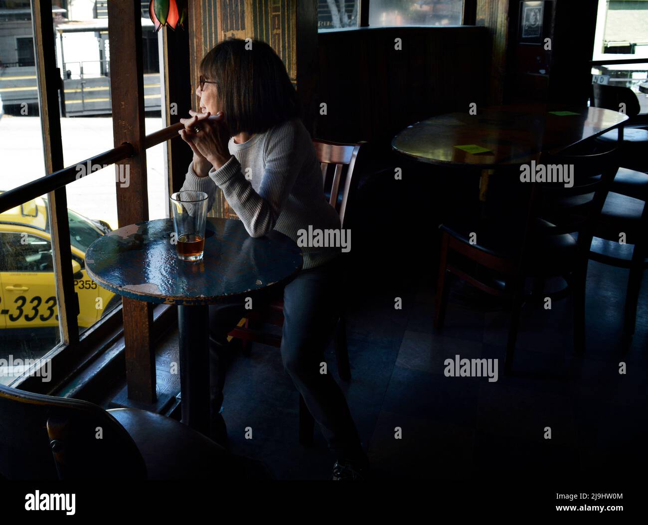 Una donna gode di una birra al Vesuvio Cafe, un caratteristico American bar nella zona di North Beach di San Francisco, California. Foto Stock