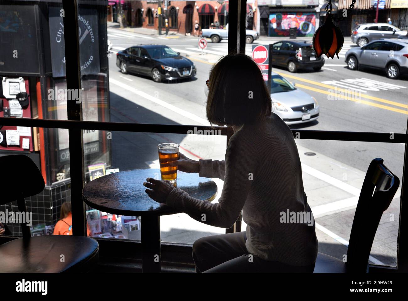 Una donna gode di una birra al Vesuvio Cafe, un caratteristico American bar nella zona di North Beach di San Francisco, California. Foto Stock