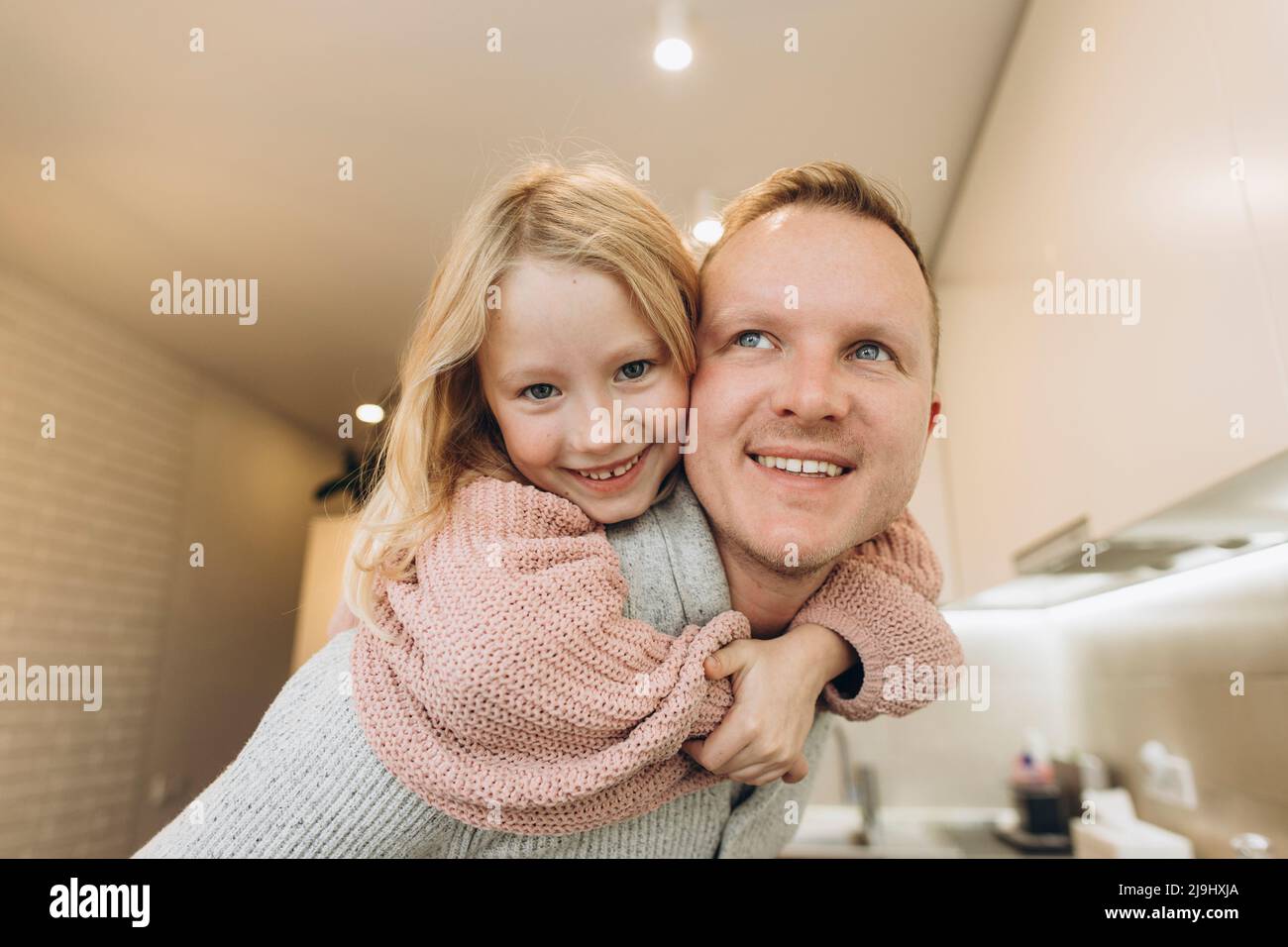 Padre che dà il giro di piggyback alla figlia a casa Foto Stock