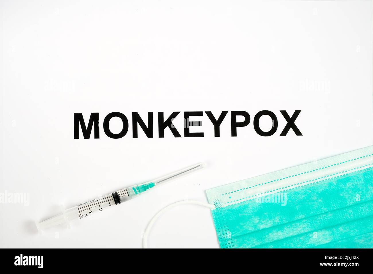 NOME dell'infezione DA MONKEYPOX visto stampato su carta con siringa e maschera medica. Concetto. Foto Stock