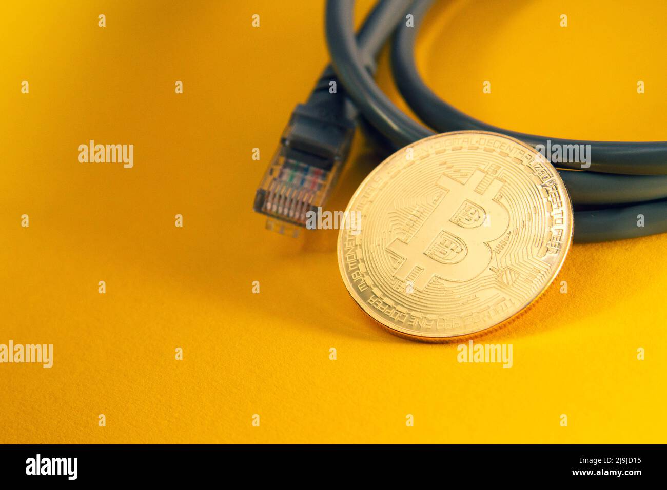Pagamento via Internet per bitcoins. Internet via cavo e monete. Criptovaluta come mezzo di pagamento. Primo piano Bitcoin. Foto Stock