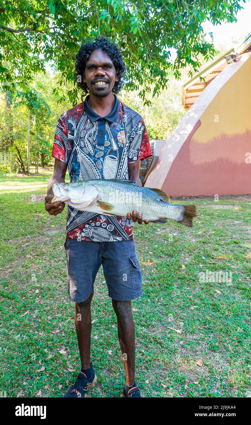 Sorridente giovane aborigeno che tiene un pesce barramundi durante il Taste of Kakadu Festival, Cooinda, Kakadu National Park, Northern Territory, NT, Aus Foto Stock