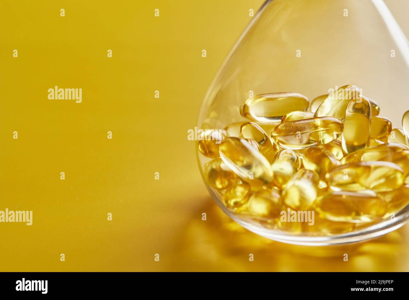 Capsule di acido grasso Omega-3 su sfondo blu in un pallone. Il concetto di medicina e di vita sana. Vista frontale. Foto Stock