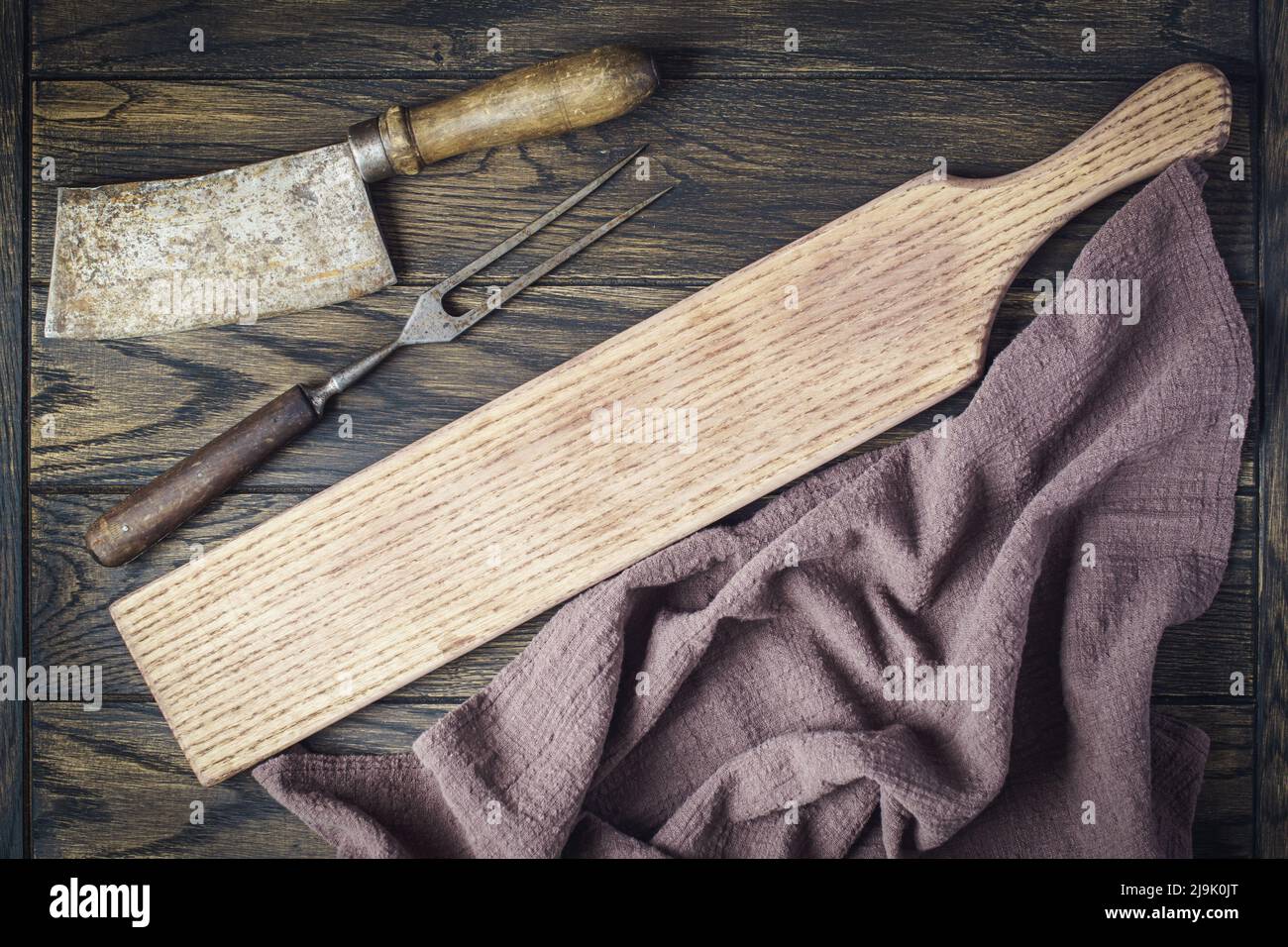 Tagliere lungo con taglierina vintage e forchetta su tavola in legno di quercia con spazio copia Foto Stock