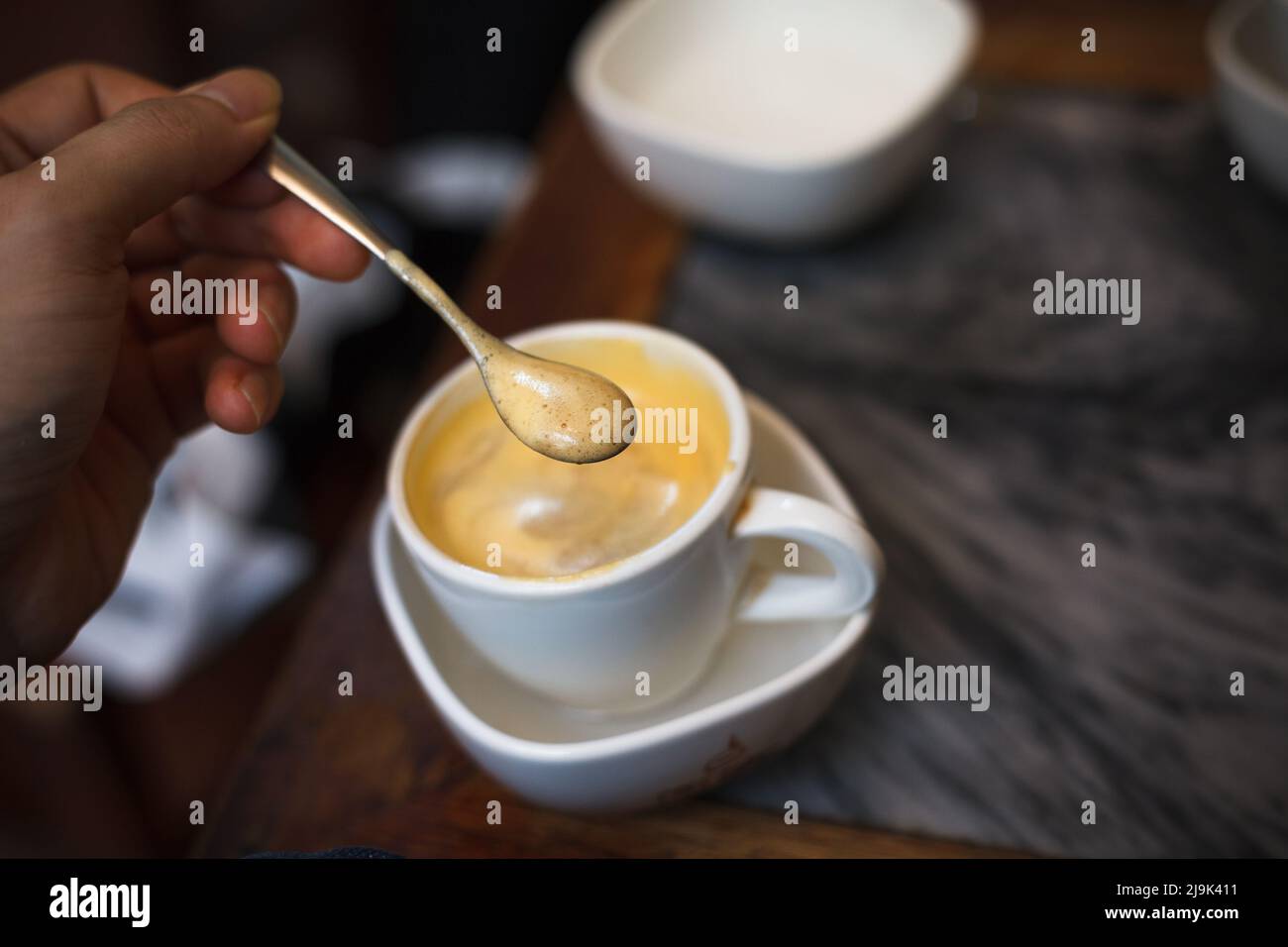 Vista dall'alto una tazza di caffè Giang uovo su sfondo di legno. Caffè vietnamita a ha noi, Vietnam. Le uova vengono sbattute con caffè, bevanda calda o ghiaccio Foto Stock
